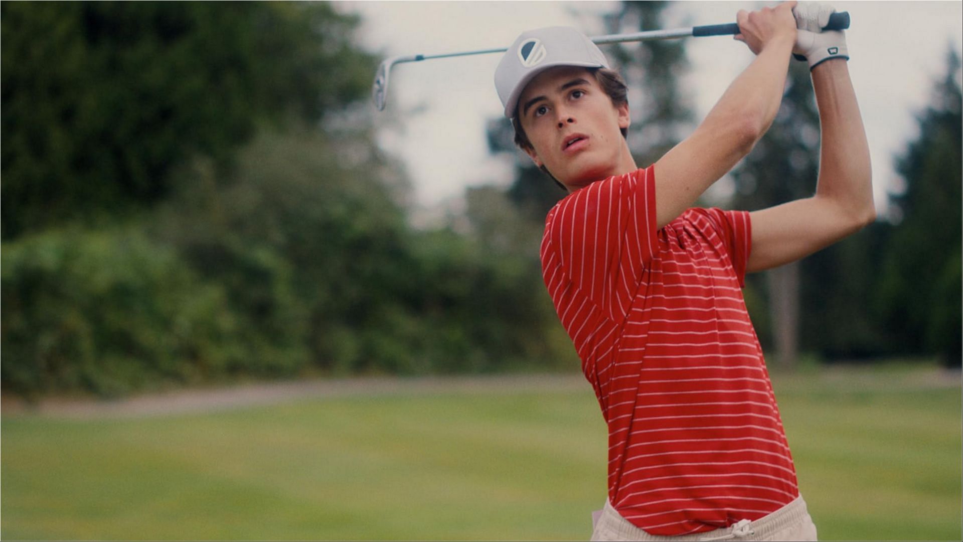 Santi takes a swing on the golf course in Stick season 1 (Image via AppleTV+)